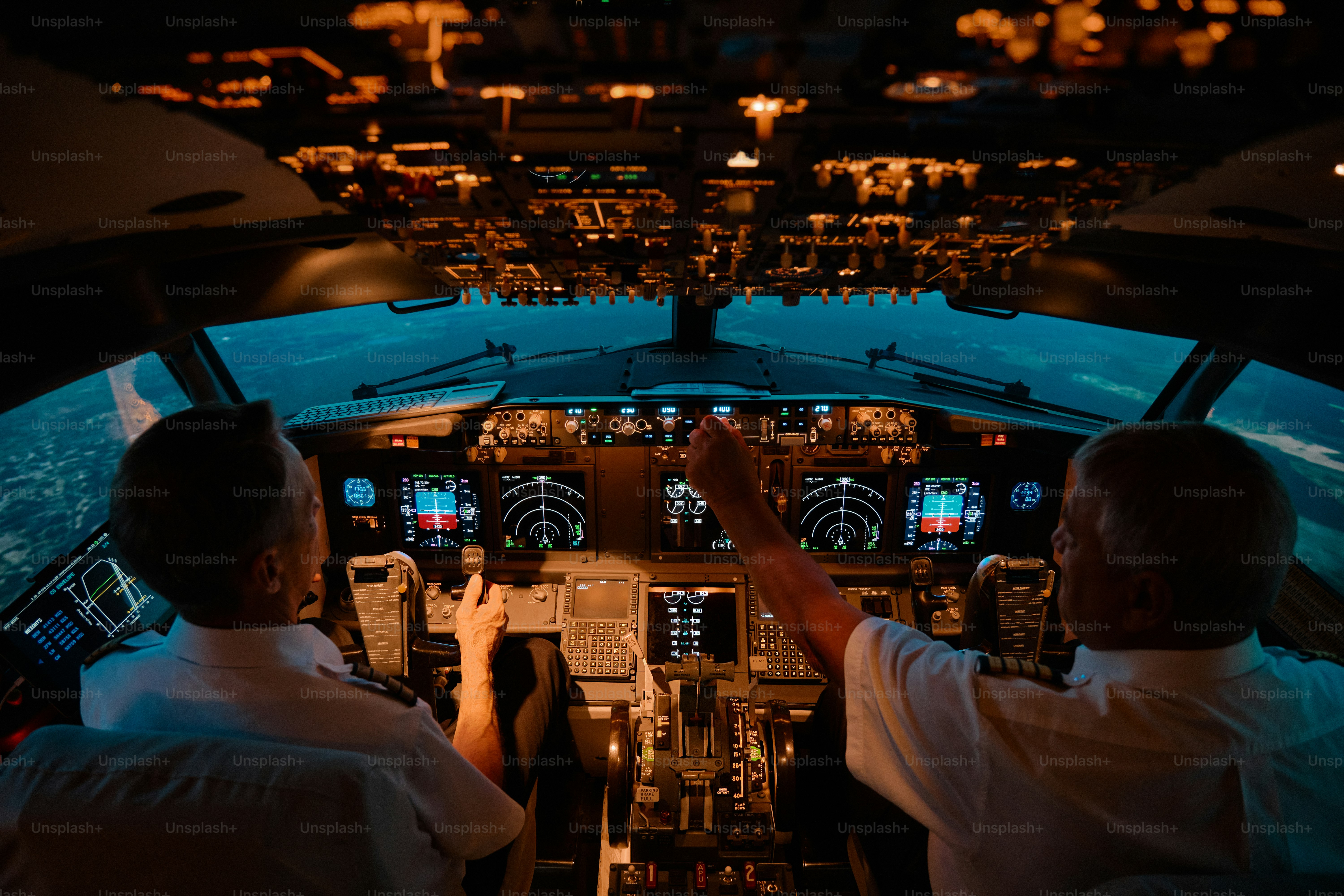 a pilots at work in the cockpit of a passenger airliner
